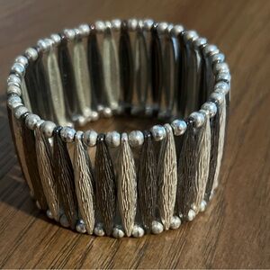 Wide stretch bracelet made of silver-tone metal with small spacer beads.